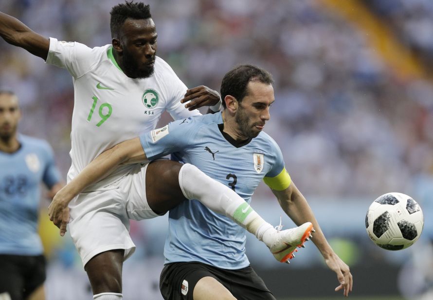 Saudi Arabia's Fahad Al-Muwallad, left, challenges Uruguay's Diego Godin.