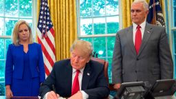 President Donald Trump signs an executive order to keep families together at the border, but says that the 'zero-tolerance' prosecution policy will continue, during an event in the Oval Office of the White House in Washington, Wednesday, June 20, 2018. Standing behind Trump are Homeland Security Secretary Kirstjen Nielsen, left, and Vice President Mike Pence. (AP Photo/Pablo Martinez Monsivais)