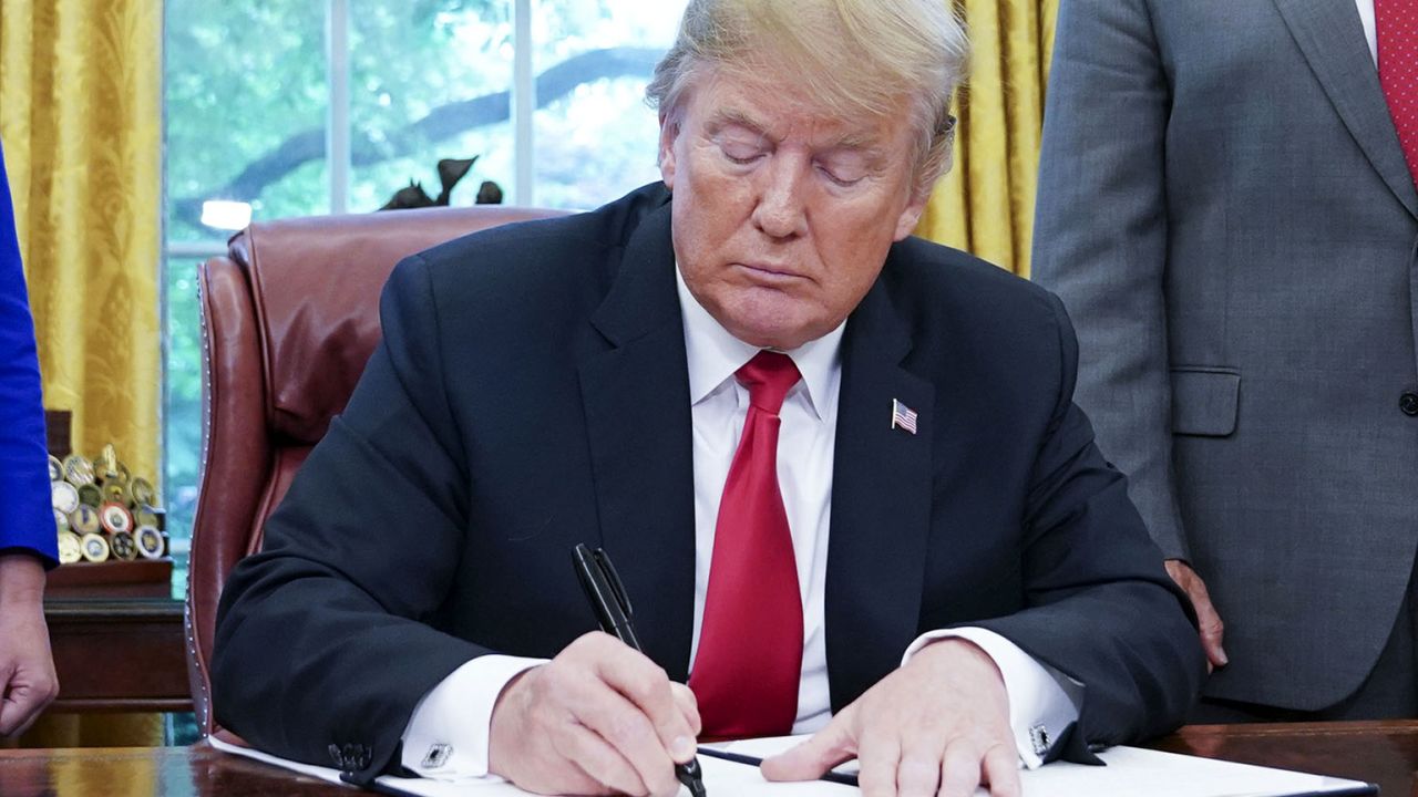 Watched by Homeland Security Secretary Kirstjen Nielsen (L) and Vice President Mike Pence, US President Donald Trump signs an executive order on immigration in the Oval Office of the White House on June 20, 2018 in Washington, DC. - US President Donald Trump on Wednesday signed an executive order aimed at putting an end to the controversial separation of migrant families at the border, reversing a harsh practice that had earned international scorn."It's about keeping families together," Trump said at the signing ceremony. "I did not like the sight of families being separated," he added. (Photo by Mandel Ngan / AFP)        (Photo credit should read MANDEL NGAN/AFP/Getty Images)