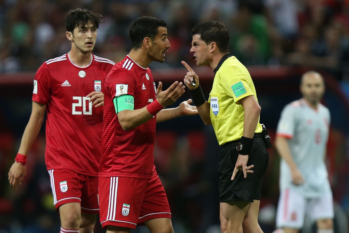 Uruguayan referee Andres Cunha speaks with Iran's midfielder Ehsan Haji Safi after the disallowed goal.