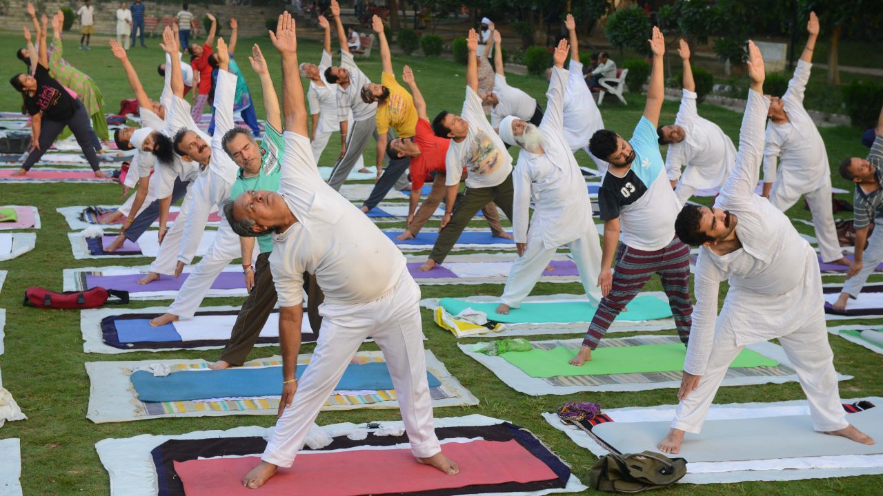 Indian yoga practitioners take part in a yoga session ahead of International Yoga Day at a park in Amritsar on June 20, 2018.