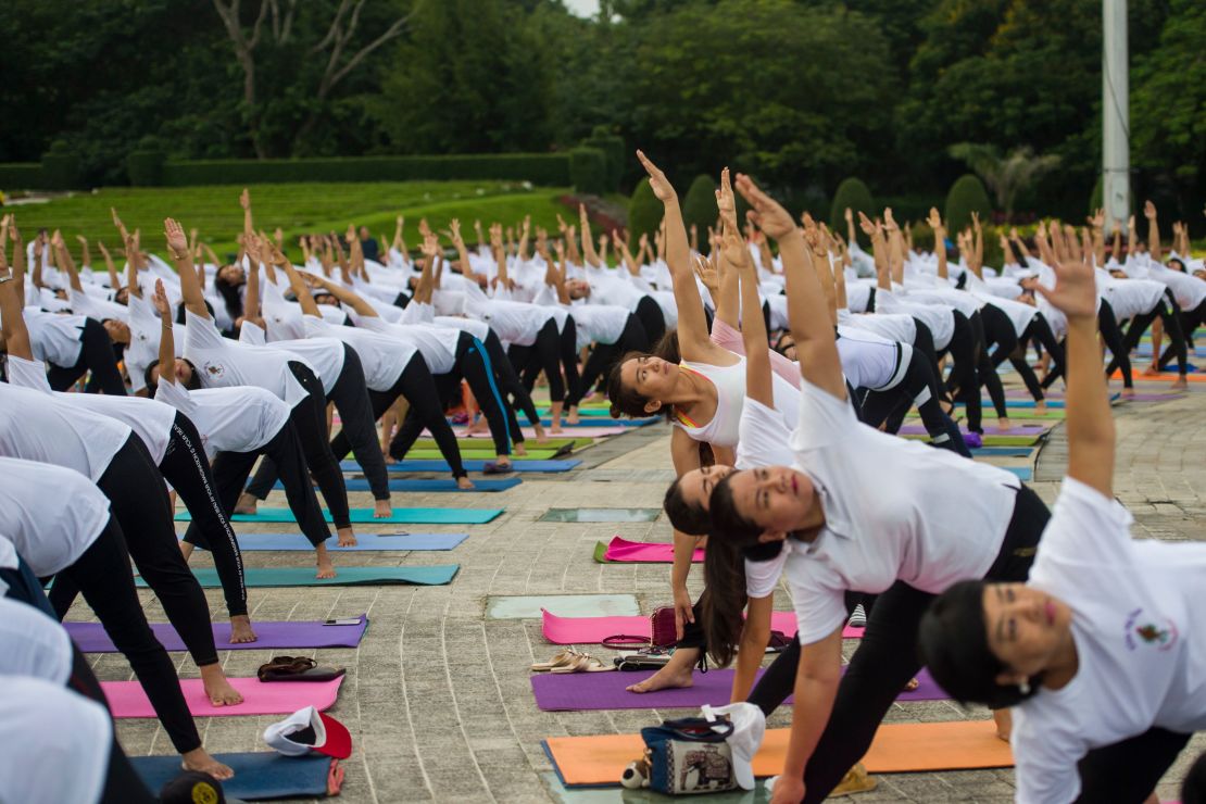 People participate in an outdoor yoga session at a park in Yangon, Myanmar to celebrate the International Yoga Day. 