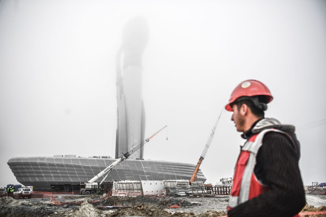 A worker looks at the control tower of a new airport under construction in Istanbul on April 13.