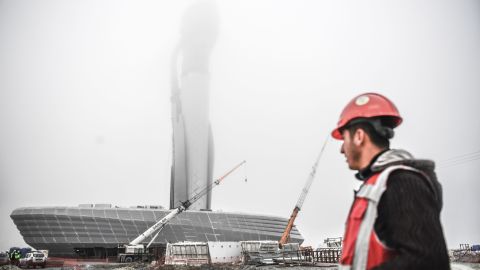 A worker looks toward the control tower of the new airport under construction in Istanbul, Turkey. Heavy spending on infrastructure has fueled the country's prosperity but also left it struggling with debt.