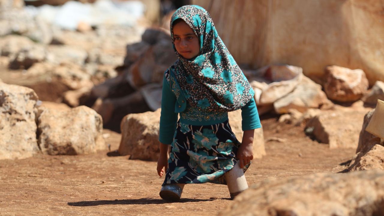 Maya Mohammad Ali Merhi walks at a camp for displaced people in Idlib, Syria, on Wednesday, June 20. The 8-year-old was born without lower limbs. Her father was unable to afford real prosthetics, so he made some for her out of tin cans.