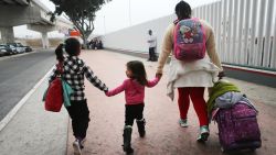 TIJUANA, MEXICO - JUNE 21:  A migrant mother walks with her two daughters on their way to cross the port of entry into the U.S. for their asylum hearing on June 21, 2018 in Tijuana, Mexico. The mother, who did not wish to give their names, said they were fleeing their hometown near the Pacific coast of Mexico after suffering a violent carjacking of her taxicab. The Trump Administration's controversial zero tolerance immigration policy led to an increase in the number of migrant children who have been separated from their families at the southern U.S. border. U.S. Attorney General Jeff Sessions has added that domestic and gang violence in immigrants' country of origin would no longer qualify them for political asylum status.  (Photo by Mario Tama/Getty Images)