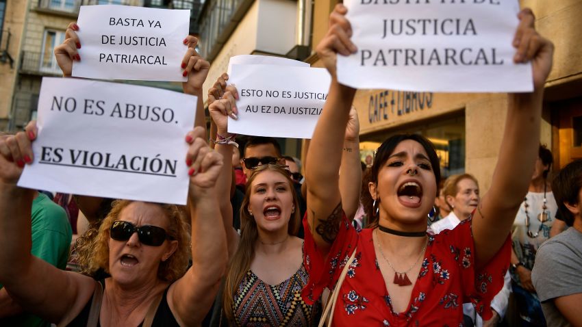 People hold up signs reading, ''It is not an abuse. It's rape'', left, and ''Enough of patriarchal justice'' while protesting against sexual abuse sentence, in Pamplona, northern Spain, Thursday, June 21, 2018. A Spanish court triggered a new wave of outrage Thursday by granting bail to five men acquitted of gang rape and convicted instead on a lesser felony of sexual abuse. It was not clear when the men might leave prison.(AP Photo/Alvaro Barrientos)