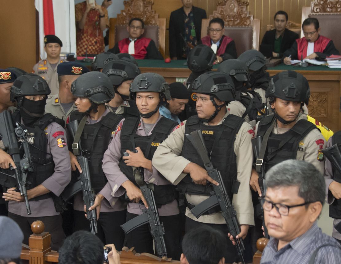 Indonesian anti-terror police officers escort Abdurrahman in court. 