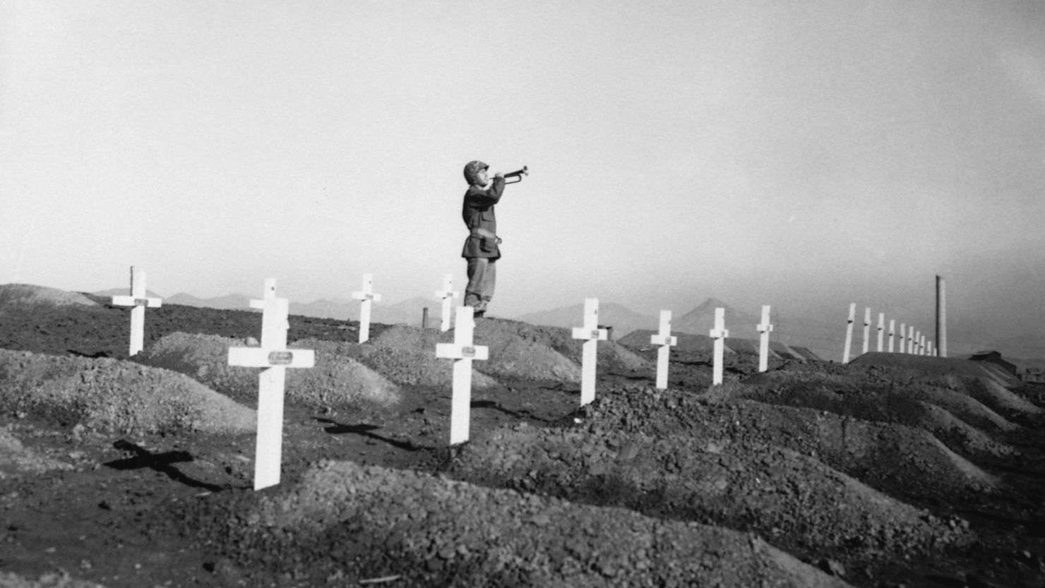 A Marine corporal stands over the graves of comrades killed in the battle for the Chosin Reservoir in December 1950.