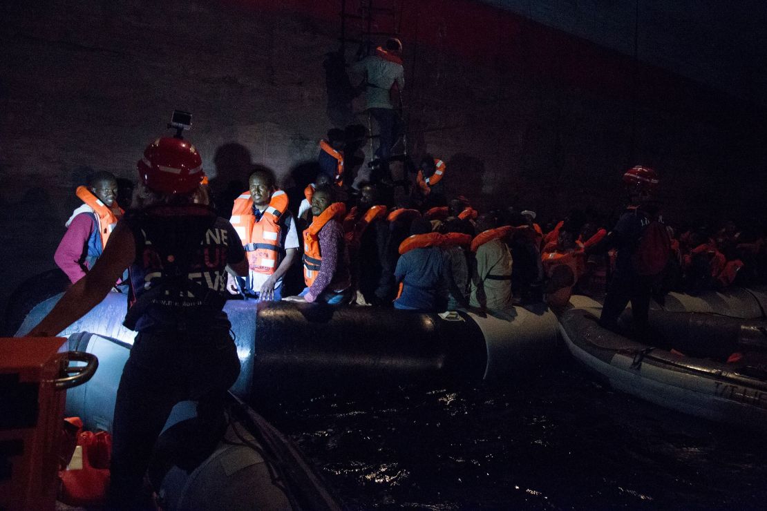 Migrants board the Danish Maersk cargo ship in darkness on Friday.  