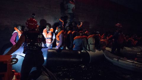 Migrants board the Danish Maersk cargo ship in darkness on Friday.  