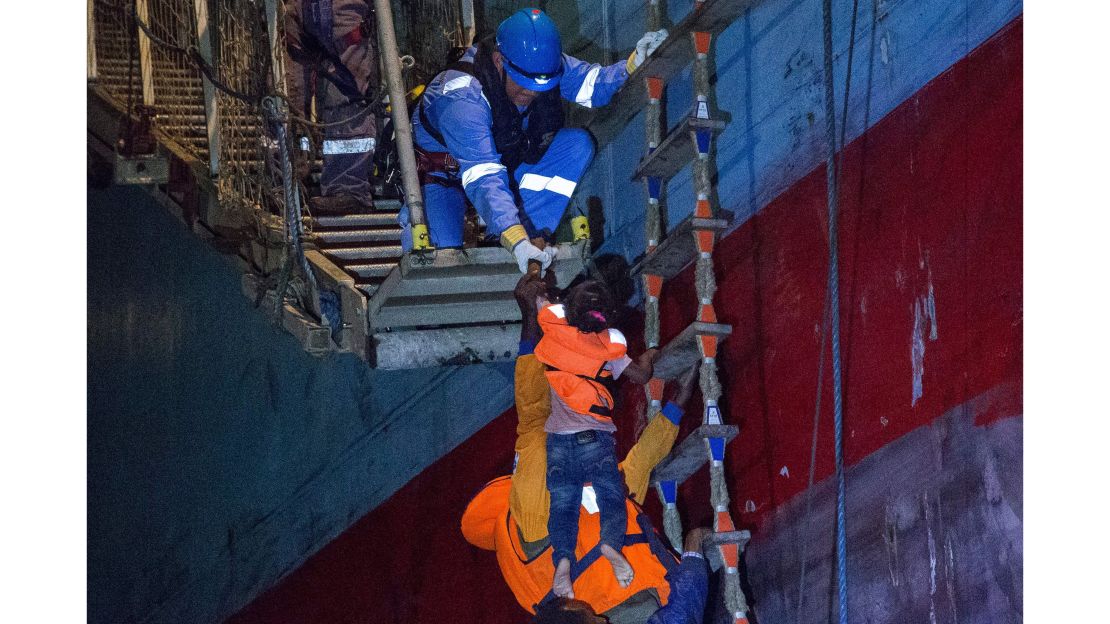 Migrants board the Maersk cargo ship on Friday.
