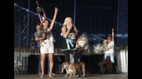 Brainard, center, celebrates after Zsa Zsa, bottom, is announced the winner of the 30th World's Ugliest Dog Contest. Also pictured are Yvonne Morones, left, and Linda Elmquist, holding their less-ugly dogs Scamp and Josie, who came in second and third, respectively. 