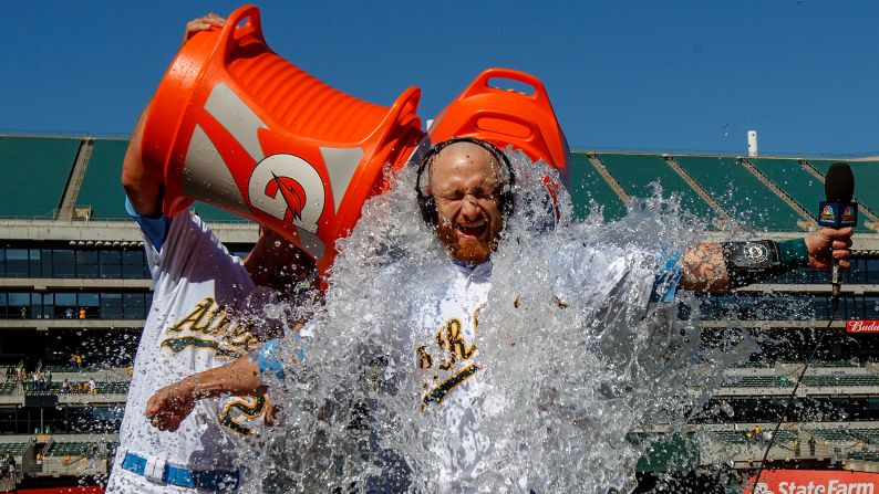 Stephen Piscotty of the Oakland Athletics, left, and Chad Pinder, unseen, pour water and Gatorade on Jonathan Lucroy after he hit a walk-off single against the Los Angeles Angels on Sunday, June 17, in Oakland, California. The Oakland Athletics defeated the Los Angeles Angels of Anaheim 6-5 in 11 innings. 