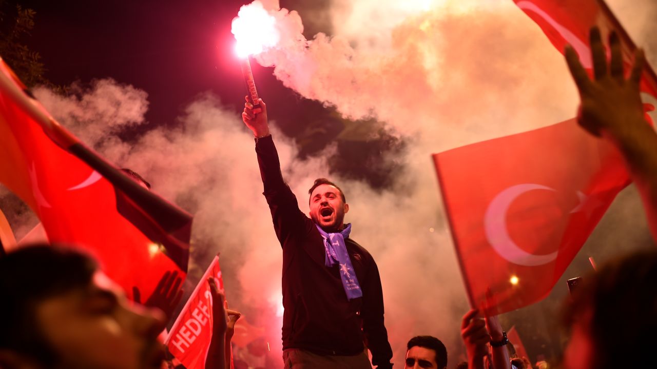 People shout slogans and let off flares after counting of votes in Turkey's presidential and parliamentary elections commenced. 