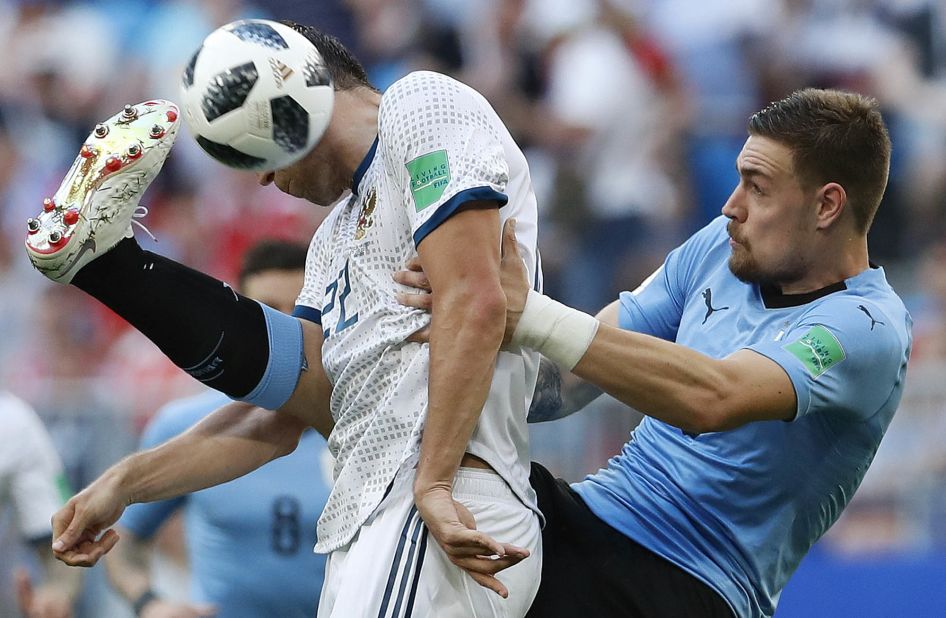 Russia's Artem Dzyuba, in white, competes with Uruguay's Sebastian Coates during Uruguay's 3-0 victory on June 25. Uruguay won all three of its matches in the group stage. This was Russia's first loss.