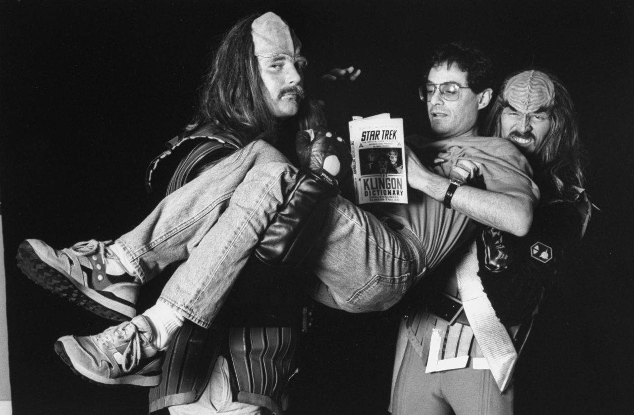 Marc Okrand, the creator of Klingon language for the Star Trek TV series, being carried by two men in Klingon costumes.