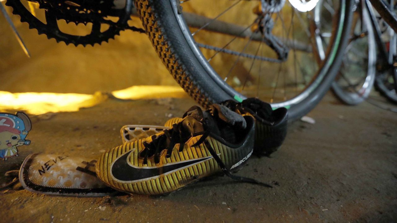 Soccer shoes are left next to bikes from the missing boys at the entrance of a cave in northern Thailand.