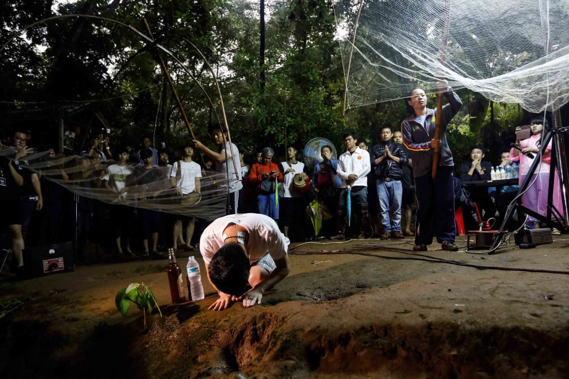 Relatives pray at the entrance of the Tham Luang Nang Non caves while rescuers search for the boys.