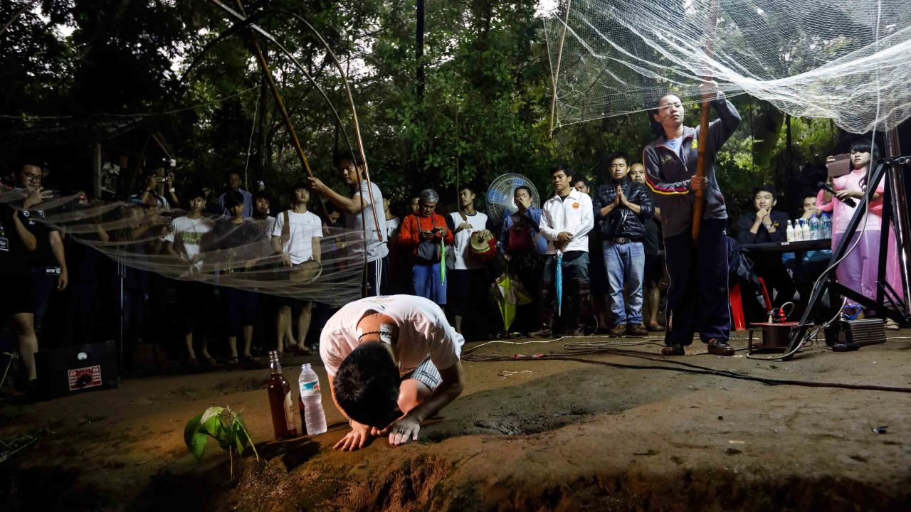 Relatives pray at the entrance of the Tham Luang Nang Non caves while rescuers search for the boys.