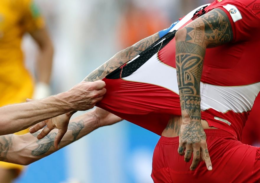 Aaron Mooy tugs on the jersey of Peru's Paolo Guerrero.