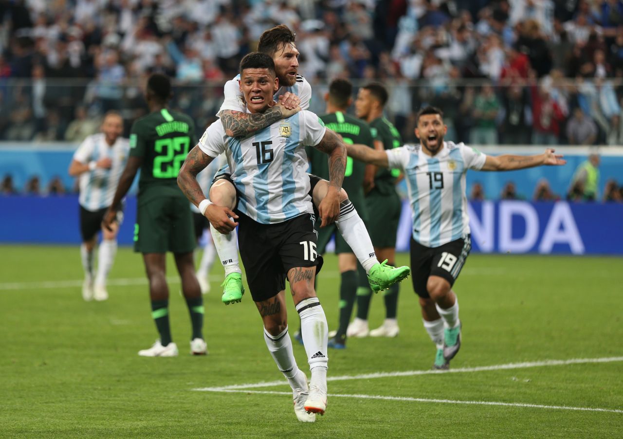 Argentina star Lionel Messi rides on the back of Marcos Rojo after Rojo's late winner against Nigeria on June 26. With the 2-1 victory, Argentina clinched a spot in the next round of the tournament.