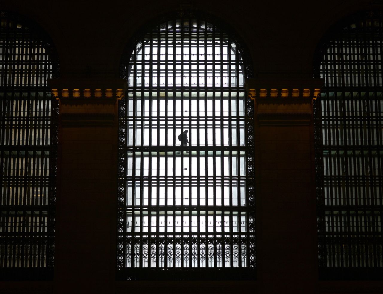 A man walks through one of the  huge arched glass windows at either end of Grand Central Terminal in New York City, a walkway for Metro North and GCT employees,  June 17, 2014.   AFP PHOTO / Timothy A. CLARY        (Photo credit should read TIMOTHY A. CLARY/AFP/Getty Images)