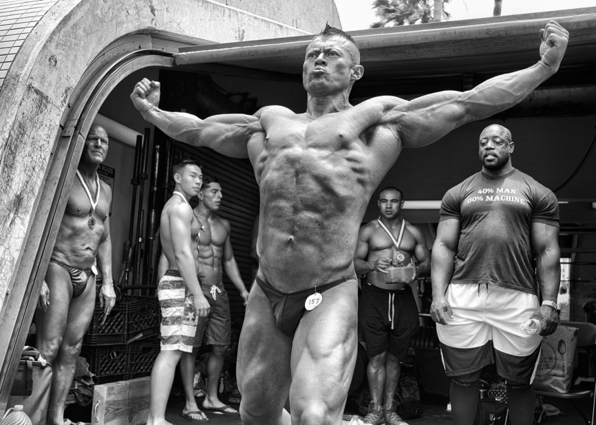 A bodybuilder practices a pose backstage at the Mr. and Mrs. Muscle Beach Competition.