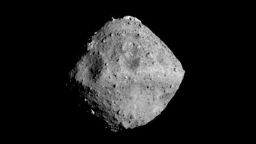 Figure 2 shows Ryugu photographed with the ONC-T (Optical Navigation Camera - Telescopic) on June 24, at around 00:01 JST. The appearance of the surface has now become much clearer. The distance between the spacecraft and the asteroid when this photo was taken was about 40 km. Figure 2: Asteroid Ryugu photographed by the ONC-T on June 24, 2018 at around 00:01 JST.
Comment by Project Manager, Yuichi Tsuda.
The shape of Ryugu is now revealed. From a distance, Ryugu initially appeared round, then gradually turned into a square before becoming a beautiful shape similar to fluorite [known as the 'firefly stone' in Japanese]. Now, craters are visible, rocks are visible and the geographical features are seen to vary from place to place. This form of Ryugu is scientifically surprising and also poses a few engineering challenges.
First of all, the rotation axis of the asteroid is perpendicular to the orbit. This fact increases the degrees of freedom for landing and the rover decent operations. On the other hand, there is a peak in the vicinity of the equator and a number of large craters, which makes the selection of the landing points both interesting and difficult. Globally, the asteroid also has a shape like fluorite (or maybe an abacus bead?). This means we expect the direction of the gravitational force on the wide areas of the asteroid surface to not point directly down. We therefore need a detailed investigation of these properties to formulate our future operation plans.
The Project Team is fascinated by the appearance of Ryugu and morale is rising at the prospect of this challenge. Together with all of you, we have become the first eyewitnesses to see asteroid Ryugu. I feel this amazing honor as we proceed with the mission operations.