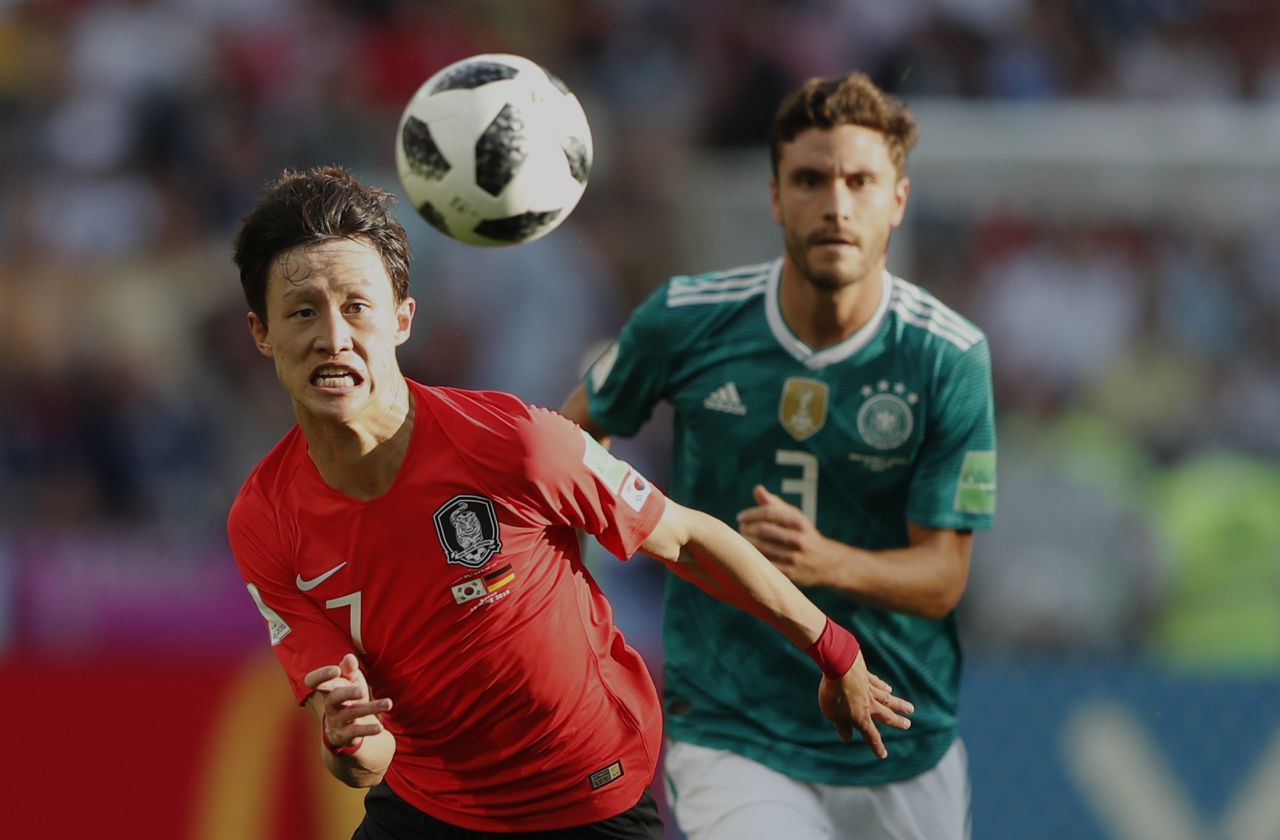 South Korea's Lee Jae-sung, left, chases down a ball with Germany's Jonas Hector.