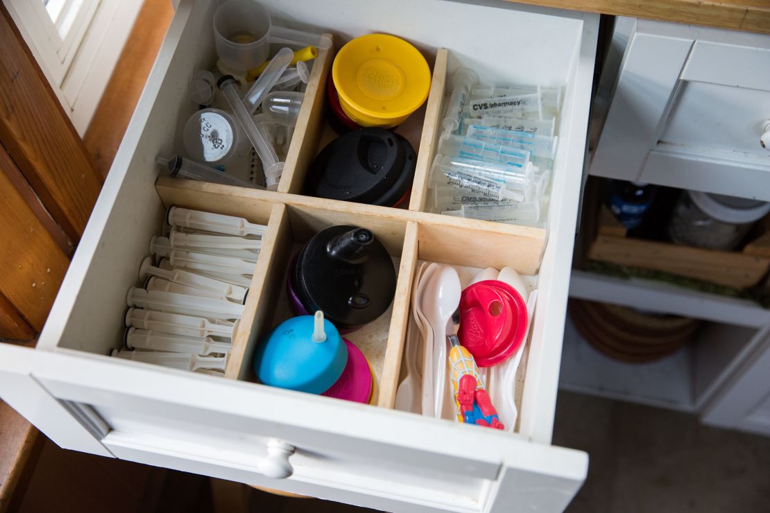 A kitchen drawer in the family home is full of syringes, next to spoons and sippy cups. 
