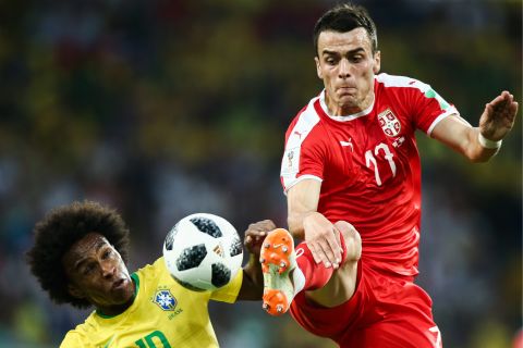 Brazil's Willian and Serbia's Filip Kostic fight for the ball.