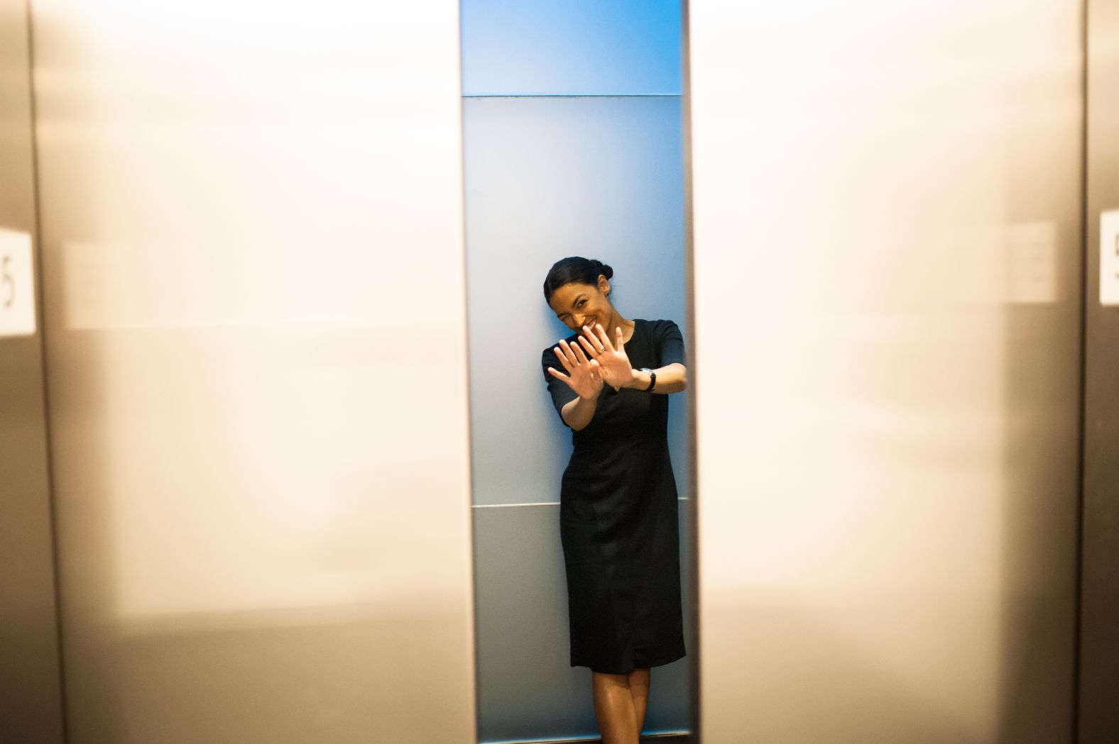 Ocasio-Cortez waves as the elevators close in the Time Warner Center in New York on Wednesday. On her way out, one of her campaign members told her about Germany's loss in the World Cup. She replied, "Must have been a big day for upsets."