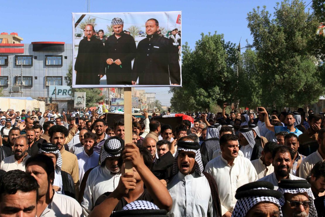 Iraqis carry a picture of some of the victims during a funeral procession in Karbala city Thursday.