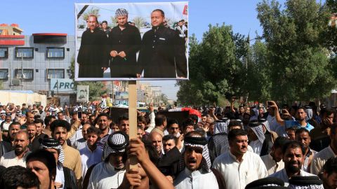 Iraqis carry a picture of some of the victims during a funeral procession in Karbala city Thursday.