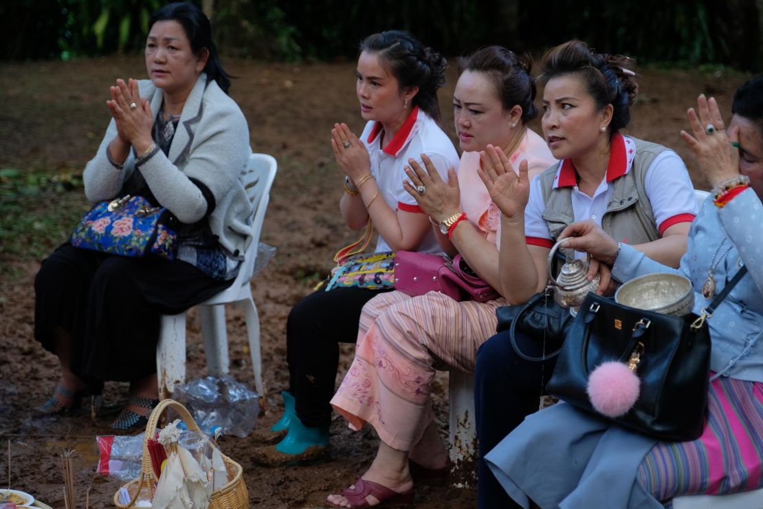 Buddhist followers pray at the entrance of Tham Luang Nang Non caves in the hope of finding the boys alive.