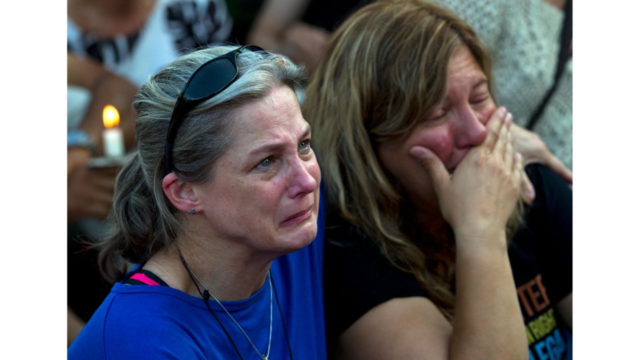 Carol Geithner, left, and Yasemin Jamison gather for a candlelight vigil in Annapolis, Maryland.