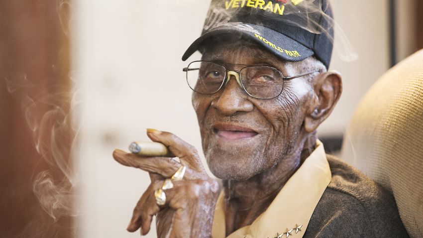 Richard Overton, the oldest living U.S. Veteran at the age of 111, is back in the east Austin home he has owned since 1948 after a renovation provided by Meals on Wheels of Central Texas and the Home Depot Foundation. He greets guests as he enjoys a cigar in the back living room, his favorite room in the house. (Ralph Barrera/Austin American-Statesman via AP)