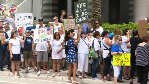 A woman holds a "Yes Melania I do care" sign at an immigration rally Saturday morning in Miami.