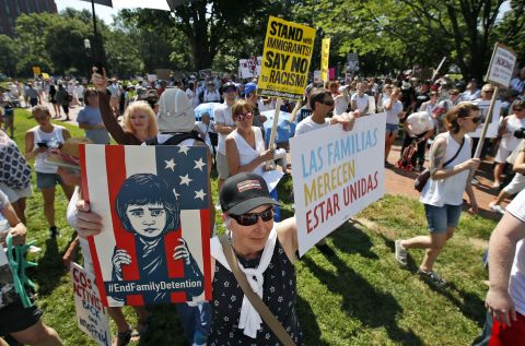 Washington: Protesters, many of them holding signs, gather in Lafayette Square across from the White House. The sign in the foreground translates as "families belong together."
