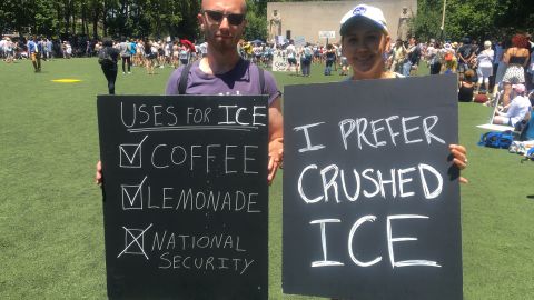 Alex Ogle, 26, and Megan Harrison, 25, hold signs in New York protesting ICE enforcement actions. 