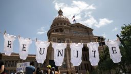 AUSTIN, TX - JUNE 30: A demonstrator uses baby clothes to spell out the word "reunite" during a rally against the Trump administration's immigration policies outside the Texas Capitol in Austin, Texas, on June 30, 2018. Demonstrations are being held in cities across the U.S. Saturday to call for the reunification of separated families and to protest the detention of children and families seeking asylum at the border. (Photo by Tamir Kalifa/Getty Images)