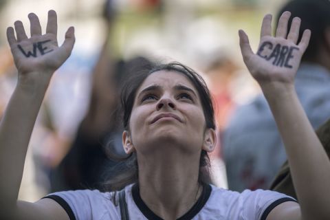 Los Angeles: A woman with "we care" written on her hands lifts them up at a protest outside the Metropolitan Detention Center.