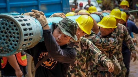 Rescue workers carry water pumping equipment into Tham Luang Nang Non cave on Sunday.