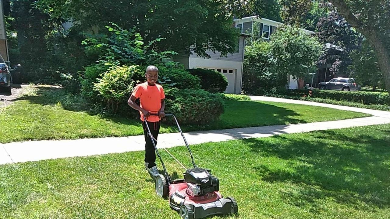 Reggie Fields, 12, mows a lawn on Sunday in Maple Heights, Ohio. His mom says he's picked up about 20 new customers since someone called the police on him for mowing the wrong yard.