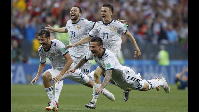 Russia's Fyodor Smolov dives as he celebrates with teammates after <a  target="_blank">Russia defeated Spain</a> in a penalty shootout during the World Cup match on Sunday, July 1. 