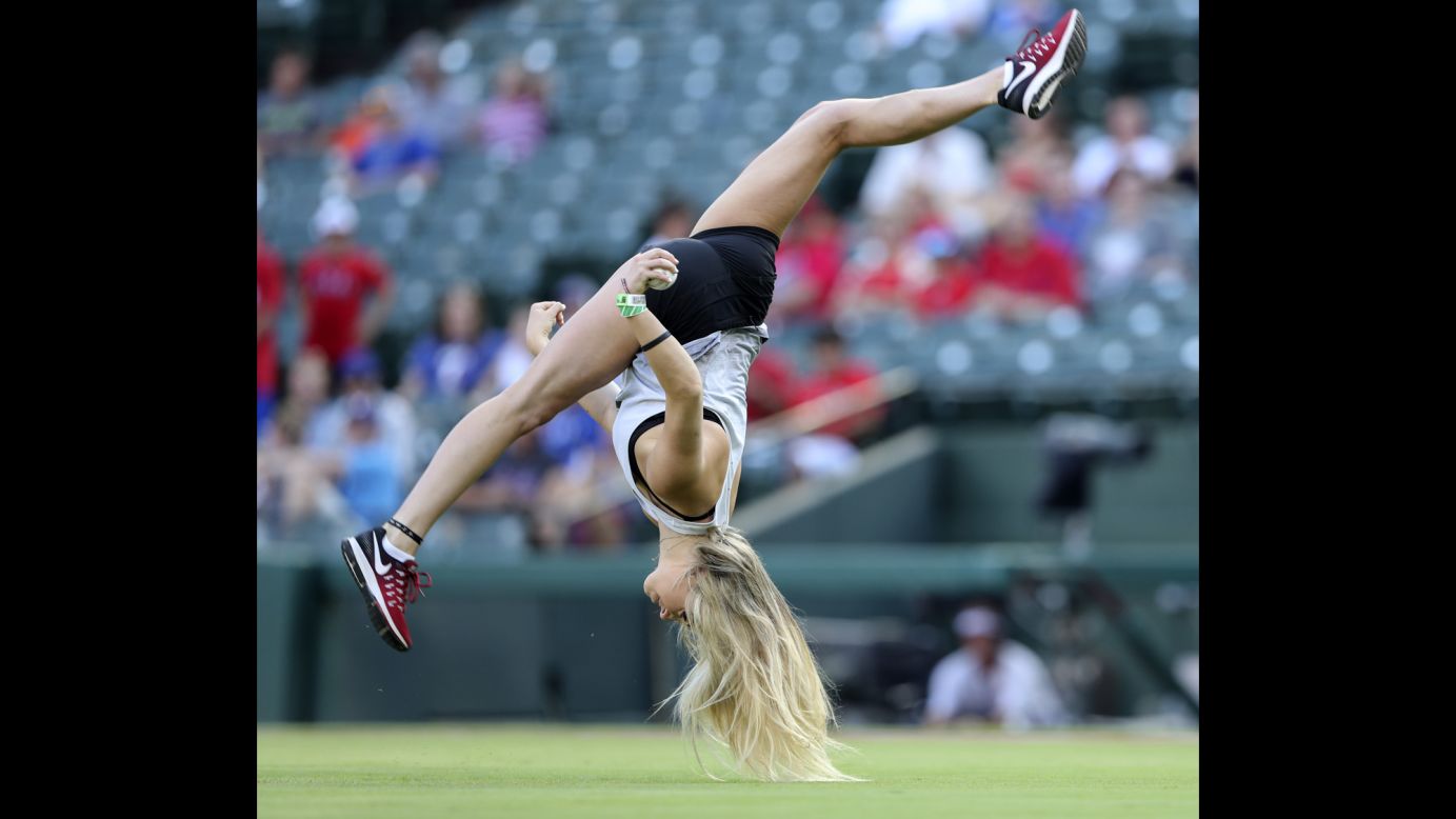 Oklahoma Sooner gymnast Natalie Brown acrobatically throws out the ceremonial first pitch before the game between the Texas Rangers and Chicago White Sox on Sunday, June 1. The White Sox defeated the Rangers 10-5.
