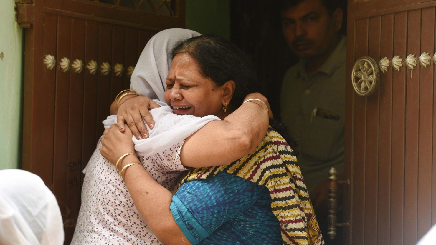 Relatives mourn outside the house, where 11 members of a family were found dead inside their home in the Indian capital of Delhi, on July 1, 2018.