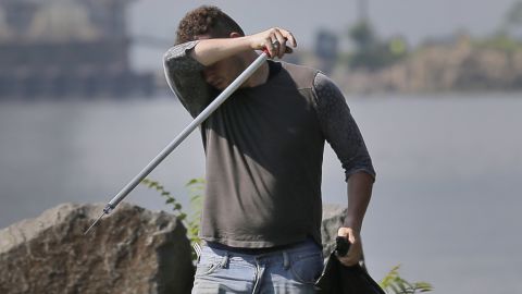 Robert Gidney, left, wipes away sweat while working in Palisades Interstate Park in Ft. Lee, N.J., Monday, July 2, 2018.