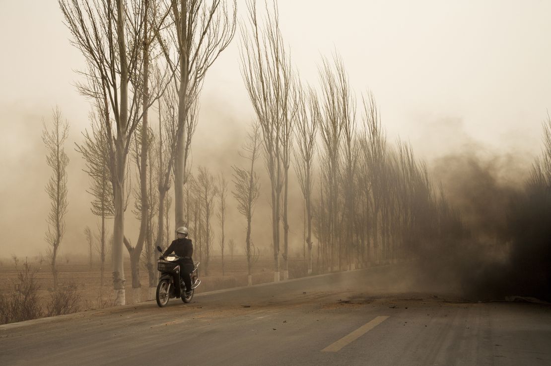 An image by Benoit Aquin of a motorbike driving through a dust storm in Bayannur, Inner Mongolia.